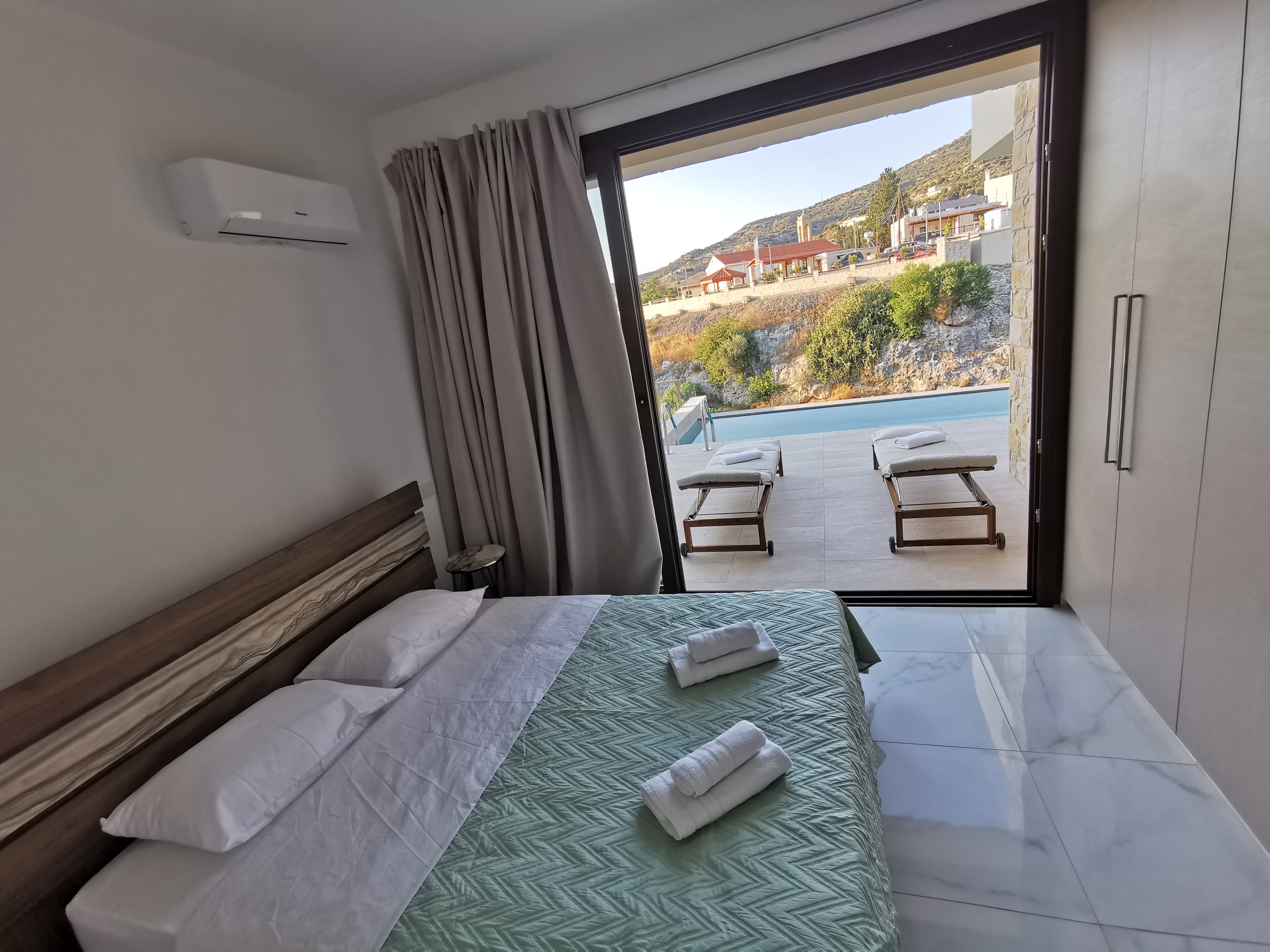 A shot of The Queen's double-bed with a stunning view of the pool