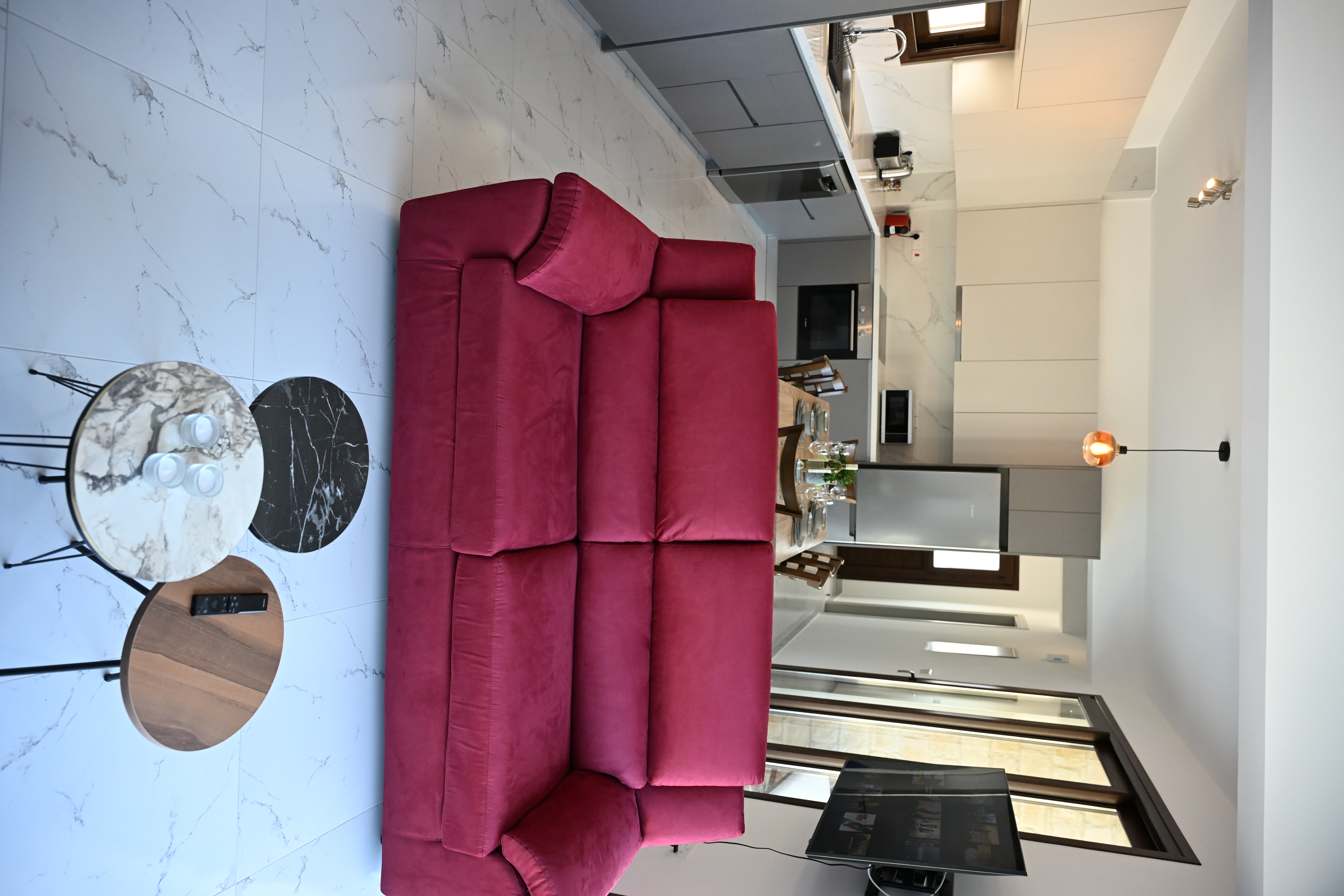 The living room and kitchen of The Prince with a giant red sofa