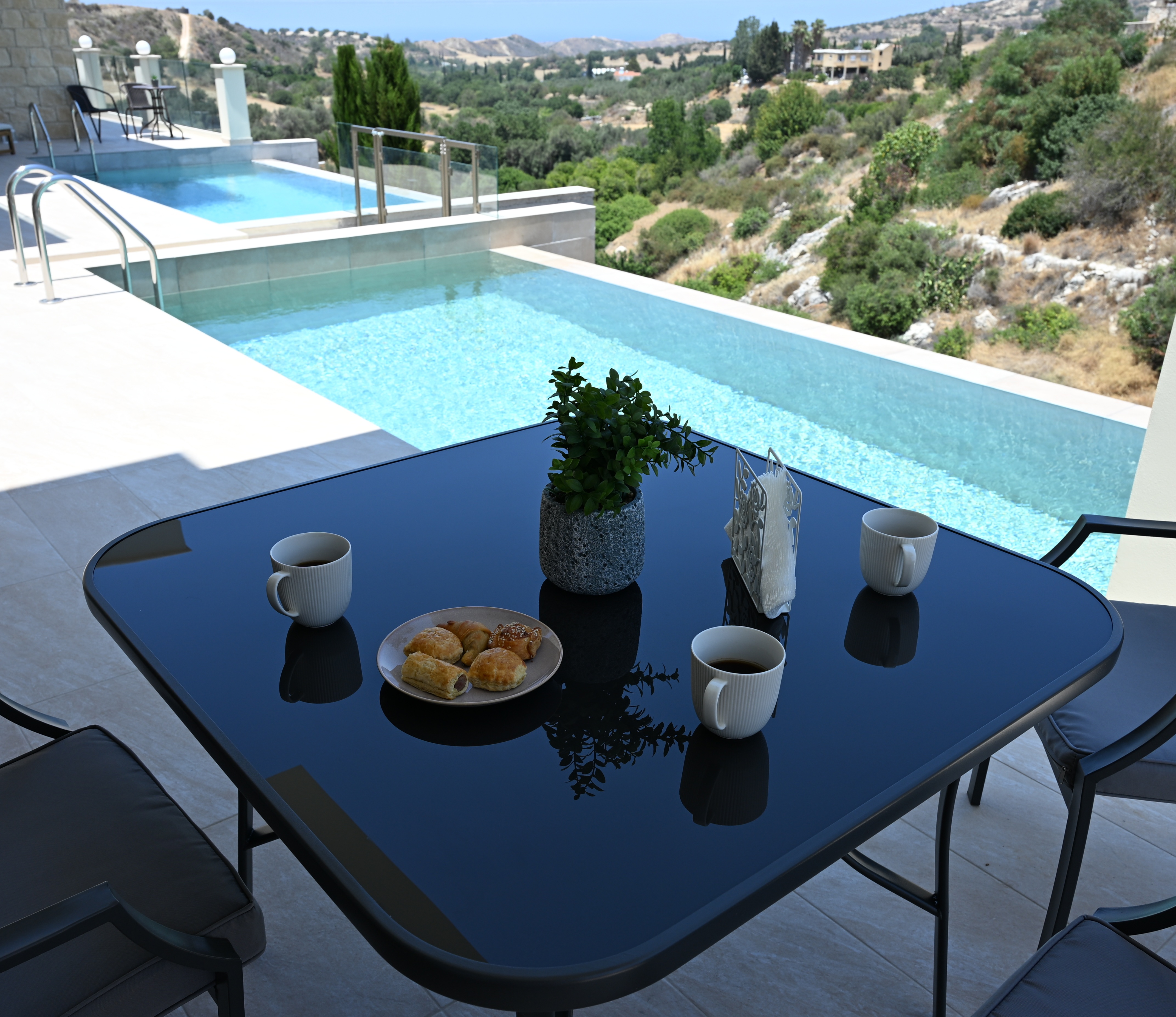 Both pools of The ROyal Houses accompanied by an aesthetic table with traditional Cypriot pastries